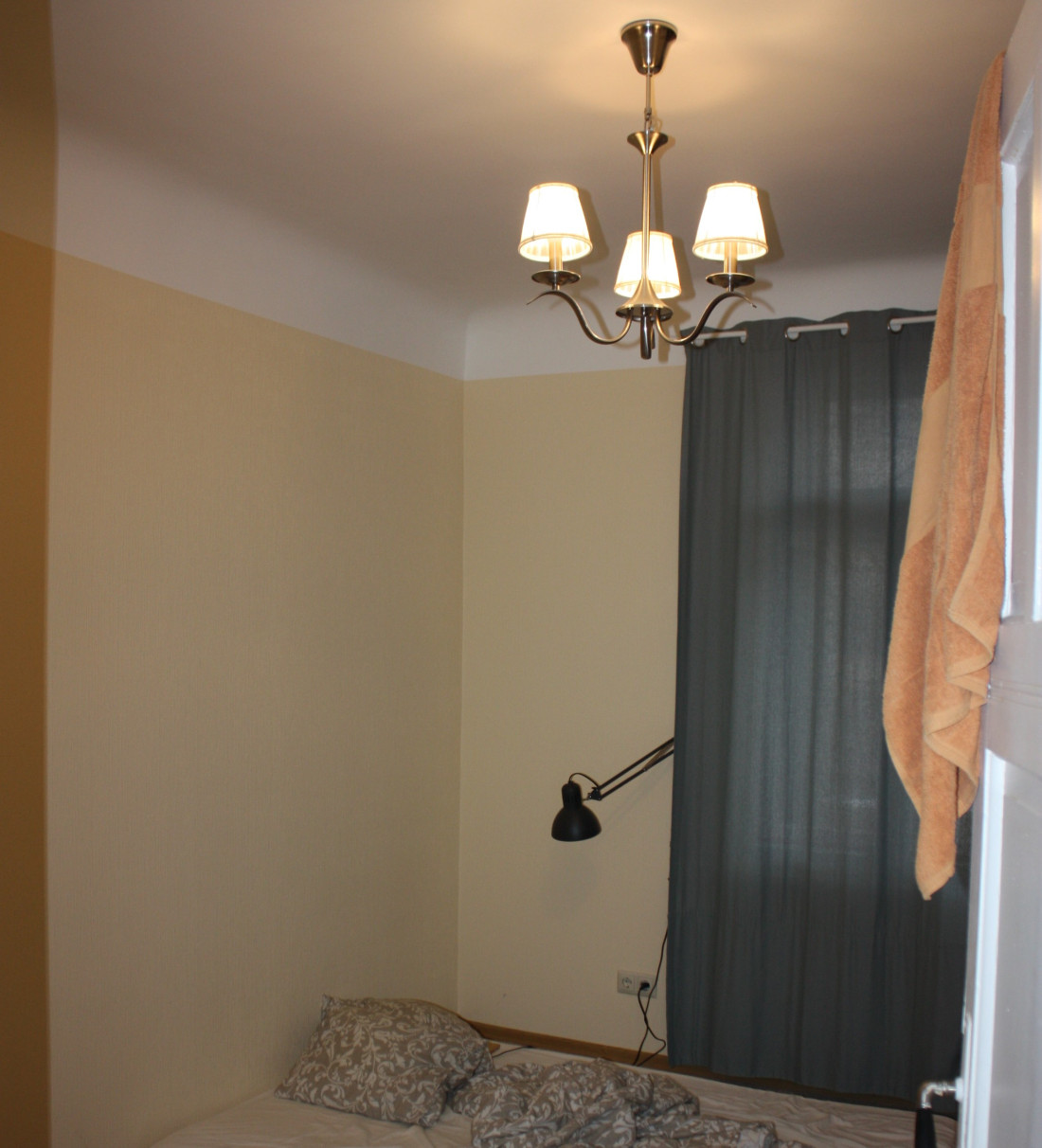 Small bedroom with bed and lamp.