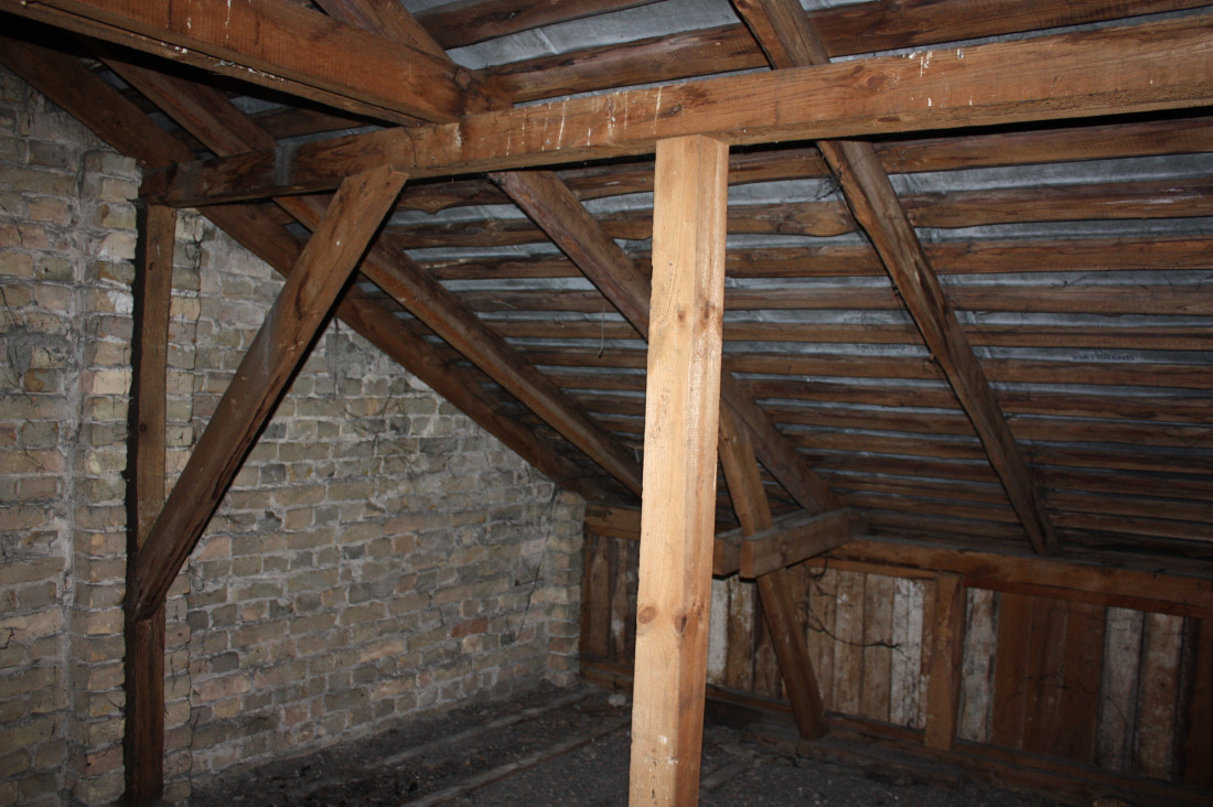Wooden attic with brick walls.