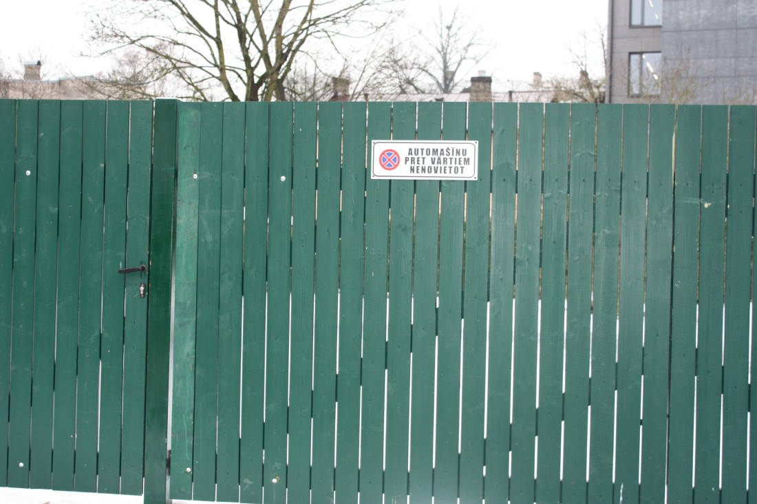  Green fence with a prohibition sign.