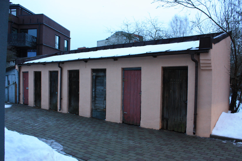 Old garages with different colored doors.