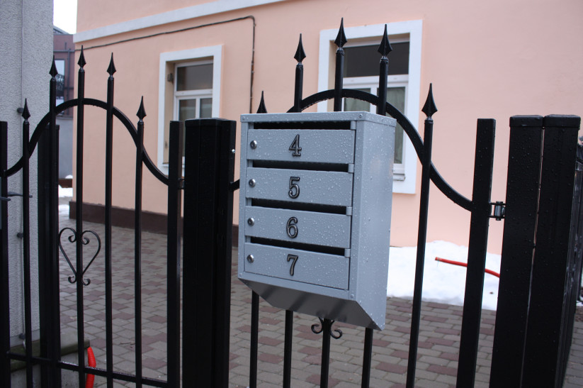 Mailboxes by iron gate.