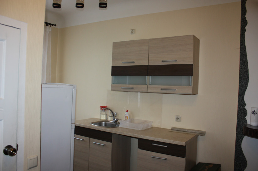Kitchen with wall cabinets and fridge.