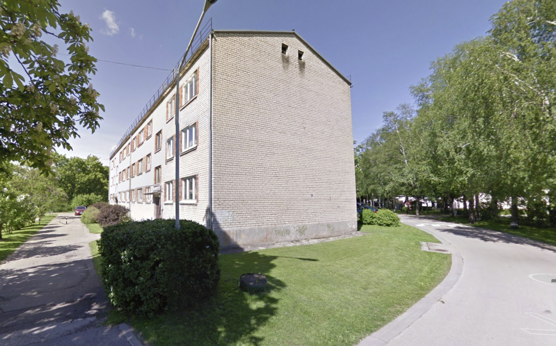 Brick building with green surroundings.