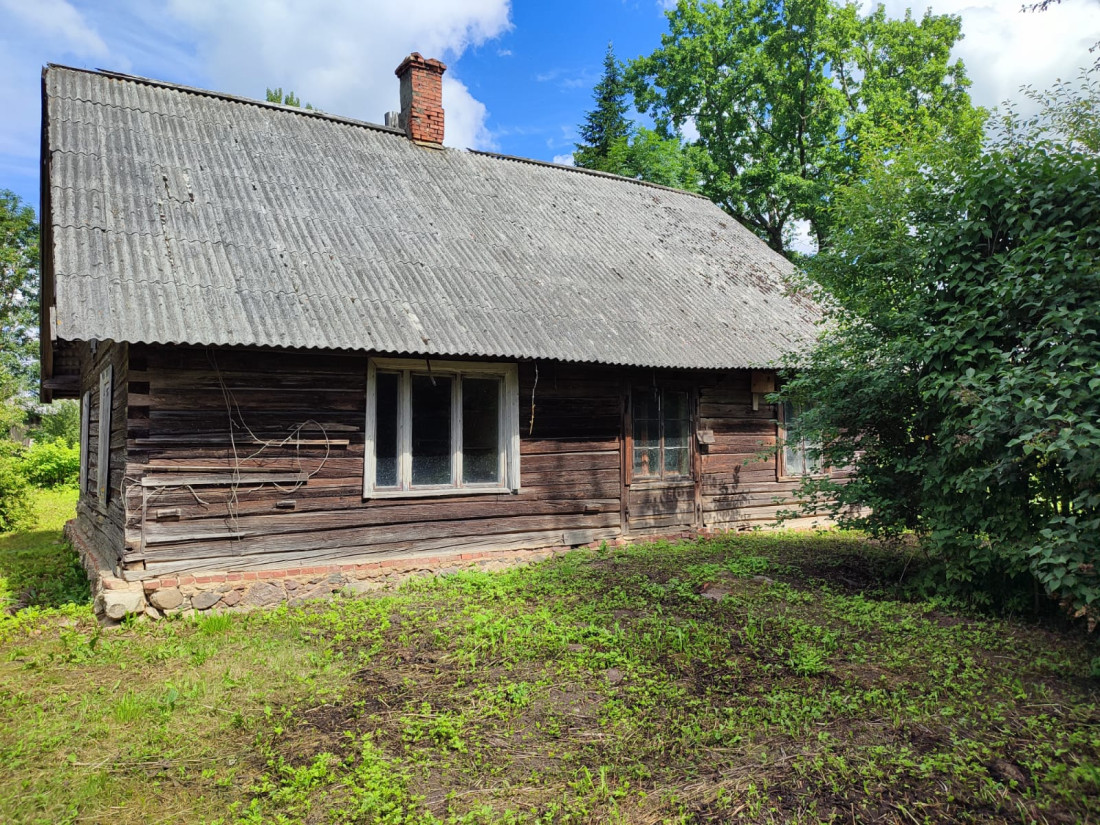 Koka māja ar lauztu jumta daļu.