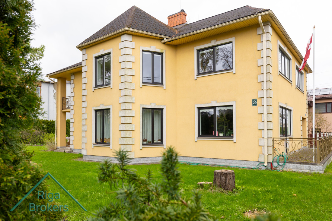 Divstāvu privātmāja ar dzeltenu fasādi.