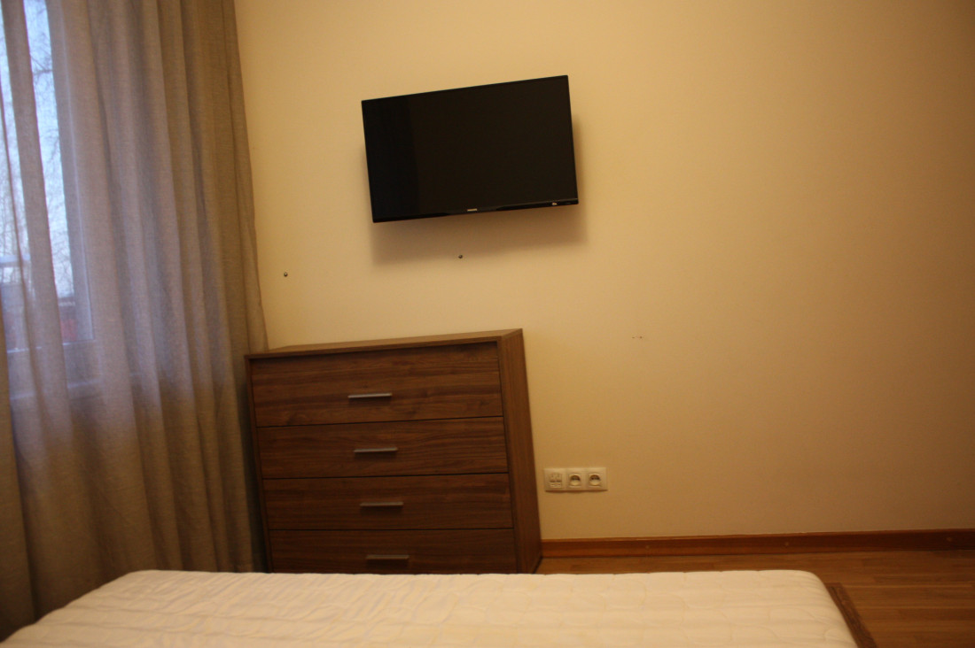 Bedroom with light furniture and wall-mounted TV