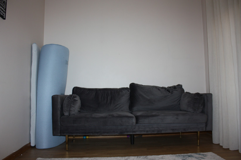Living room with a gray couch and yoga mat