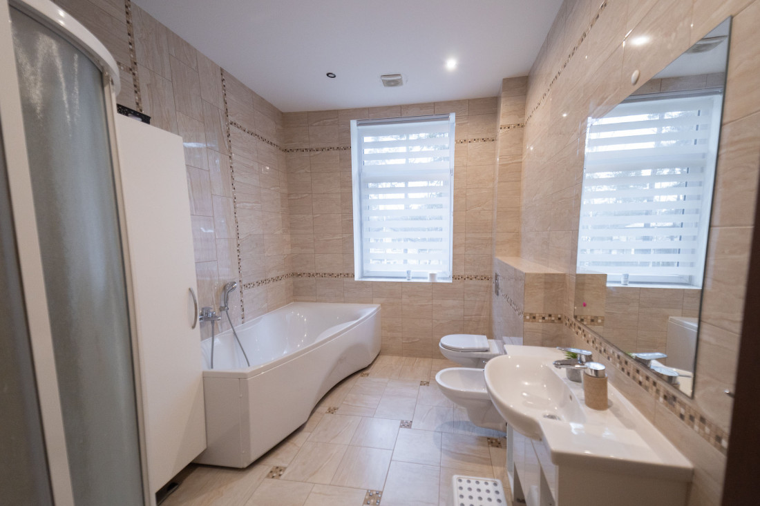 Bathroom with white tiled finish and bathtub