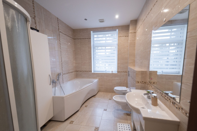 Bathroom with white tiled finish and bathtub