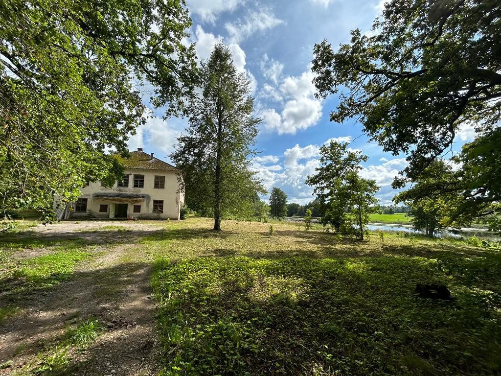 Lauku māja ar pagalmu un kokiem.