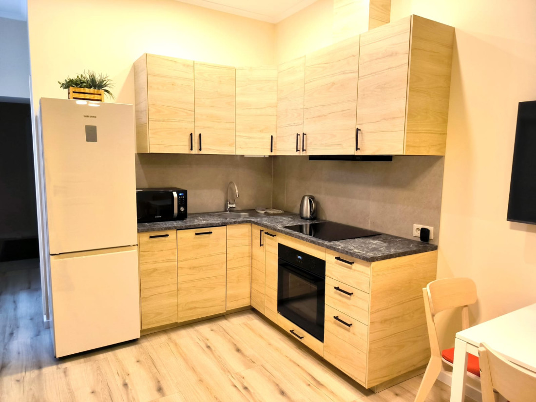 Small kitchen with wooden cabinets and white appliances.