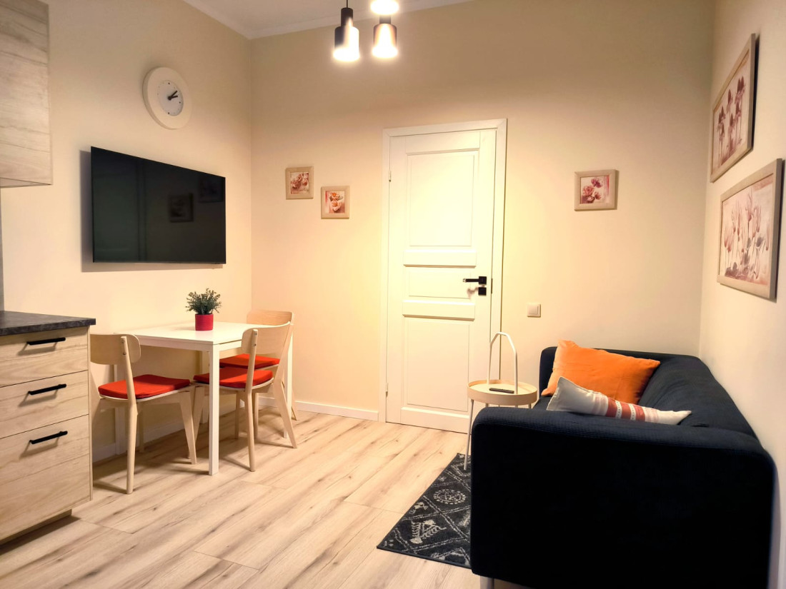 Living area with dark sofa and dining table.