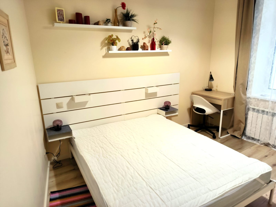 Bedroom with white furniture and a workstation.