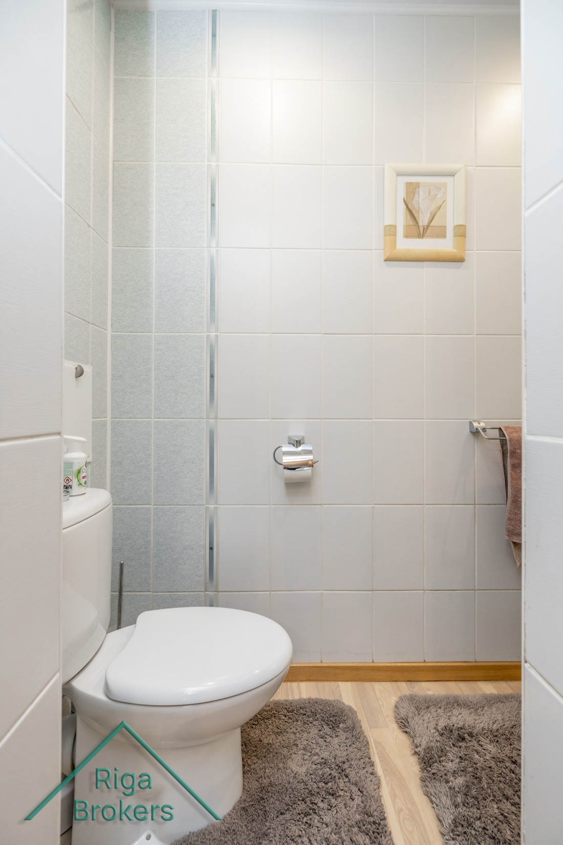 Toilet area with white tiles.