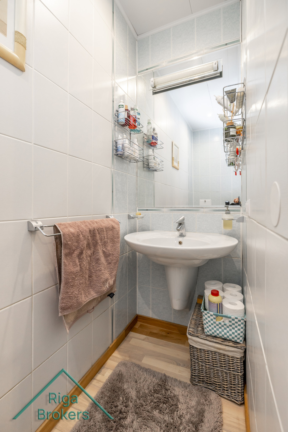 Small bathroom corner with sink and mirror.