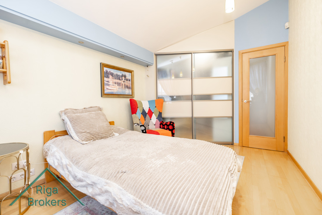 Bed and colorful chair in a modern bedroom.