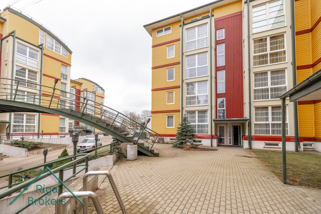 Residential building with colorful facade and footbridge.