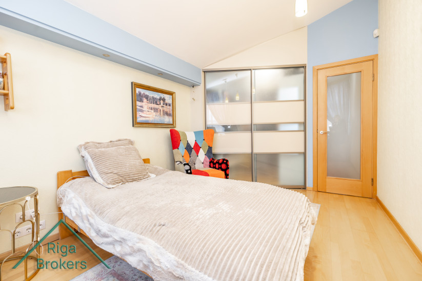 Bed and colorful chair in a modern bedroom.