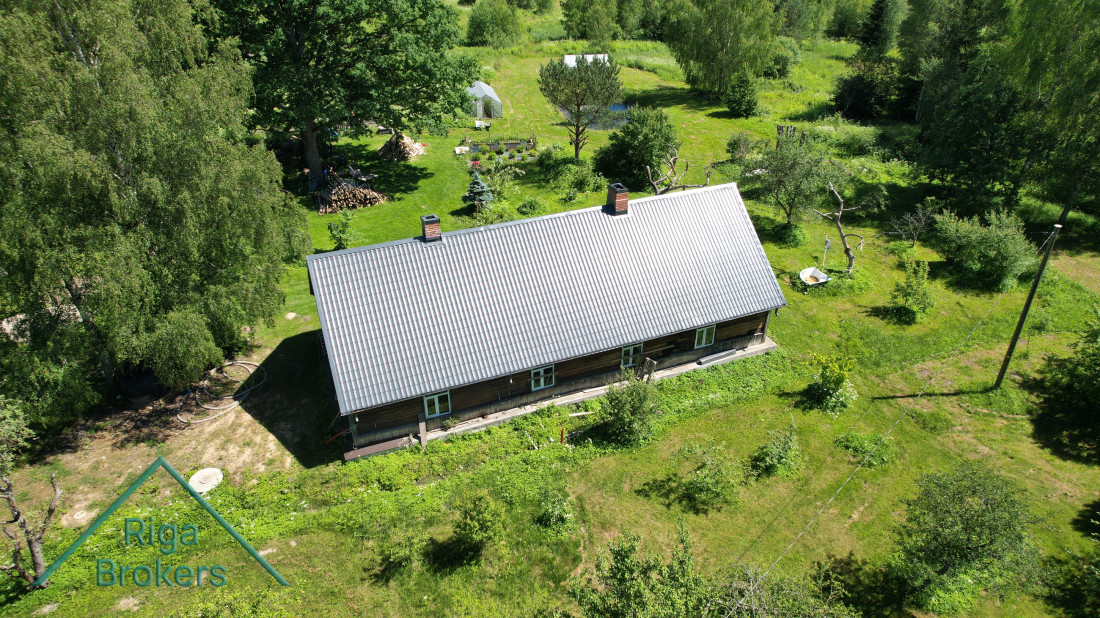 Countryside house in a green meadow with a pond.