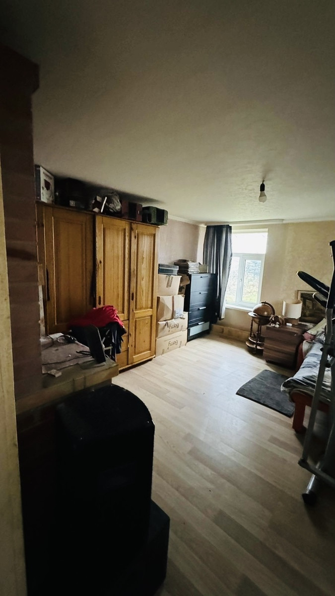 Room with wardrobes and wooden floor.