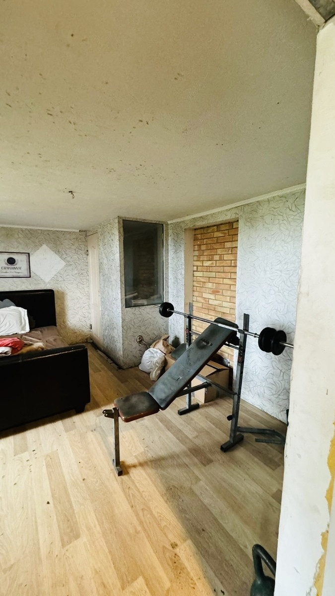 Room with exercise equipment and brick wall.