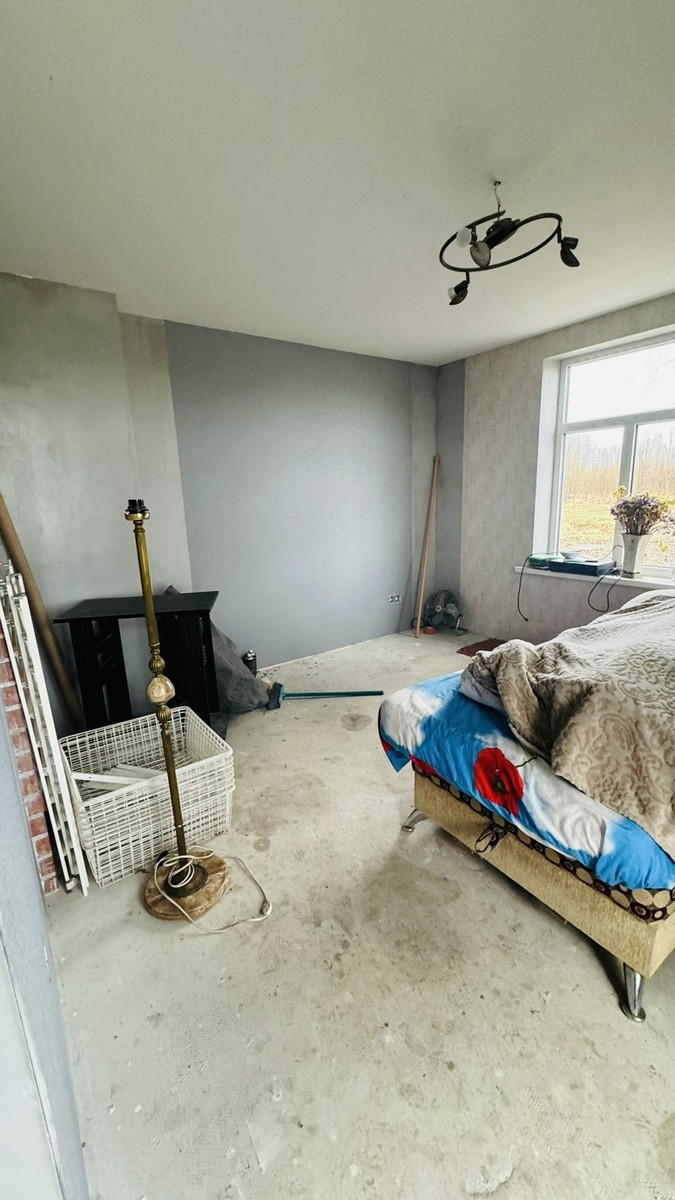 Room with a bed and grey walls.