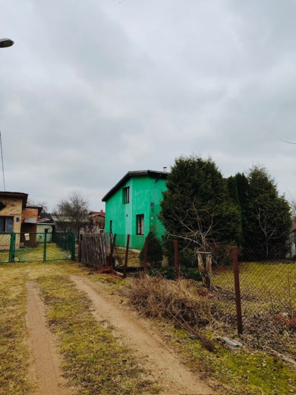 Māja ar žogu un zaļumiem ap to.