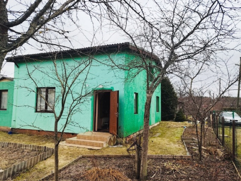 Māja ar ieejas durvīm un koku priekšā.