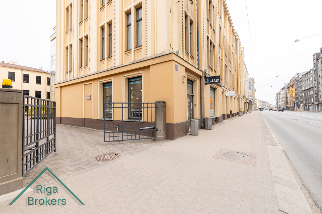 Stūra ēkas fasāde ar ieeju.
