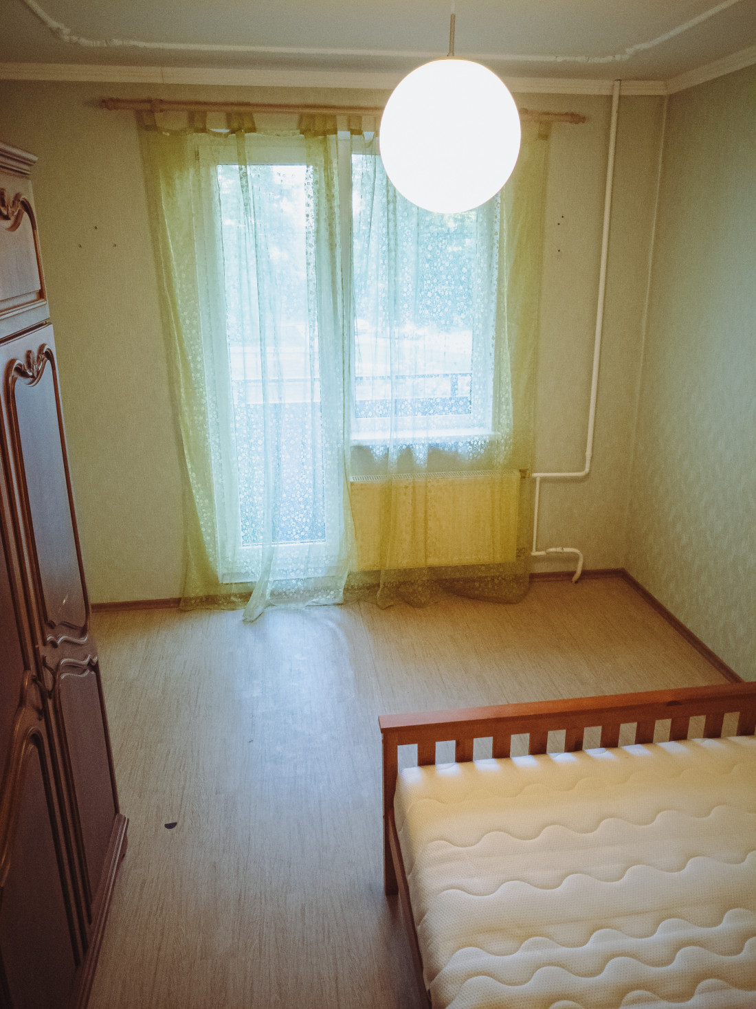 Bedroom with wooden bed and wardrobe.