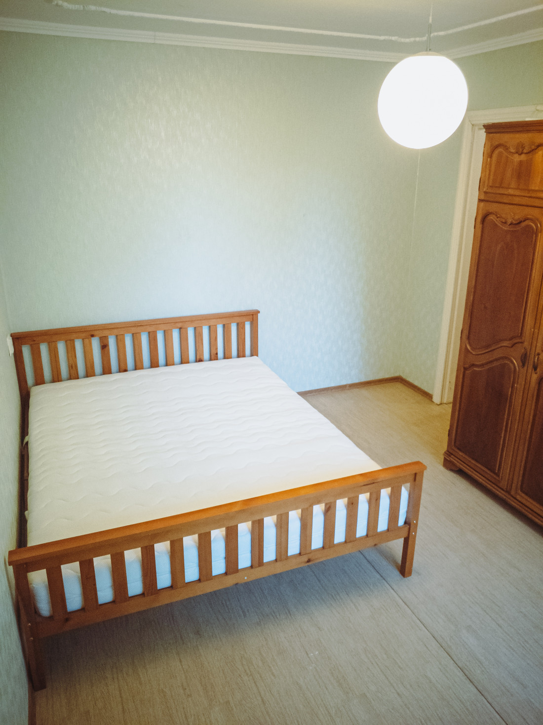Bedroom with wooden bed and wardrobe.