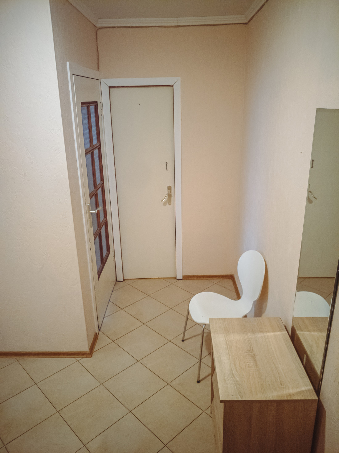 Hallway with white walls and a mirror.
