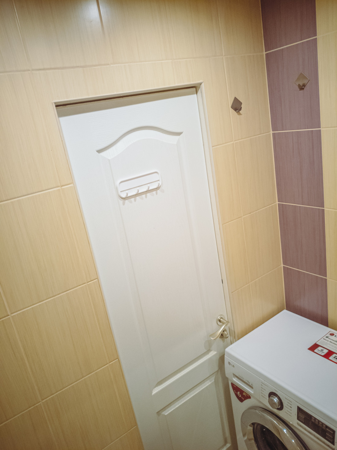 Tiled bathroom door and washing machine