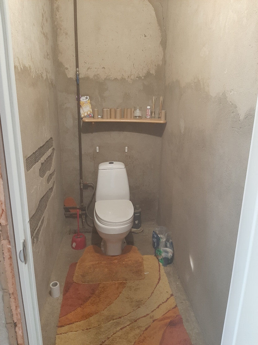 Toilet with shelves on the wall.