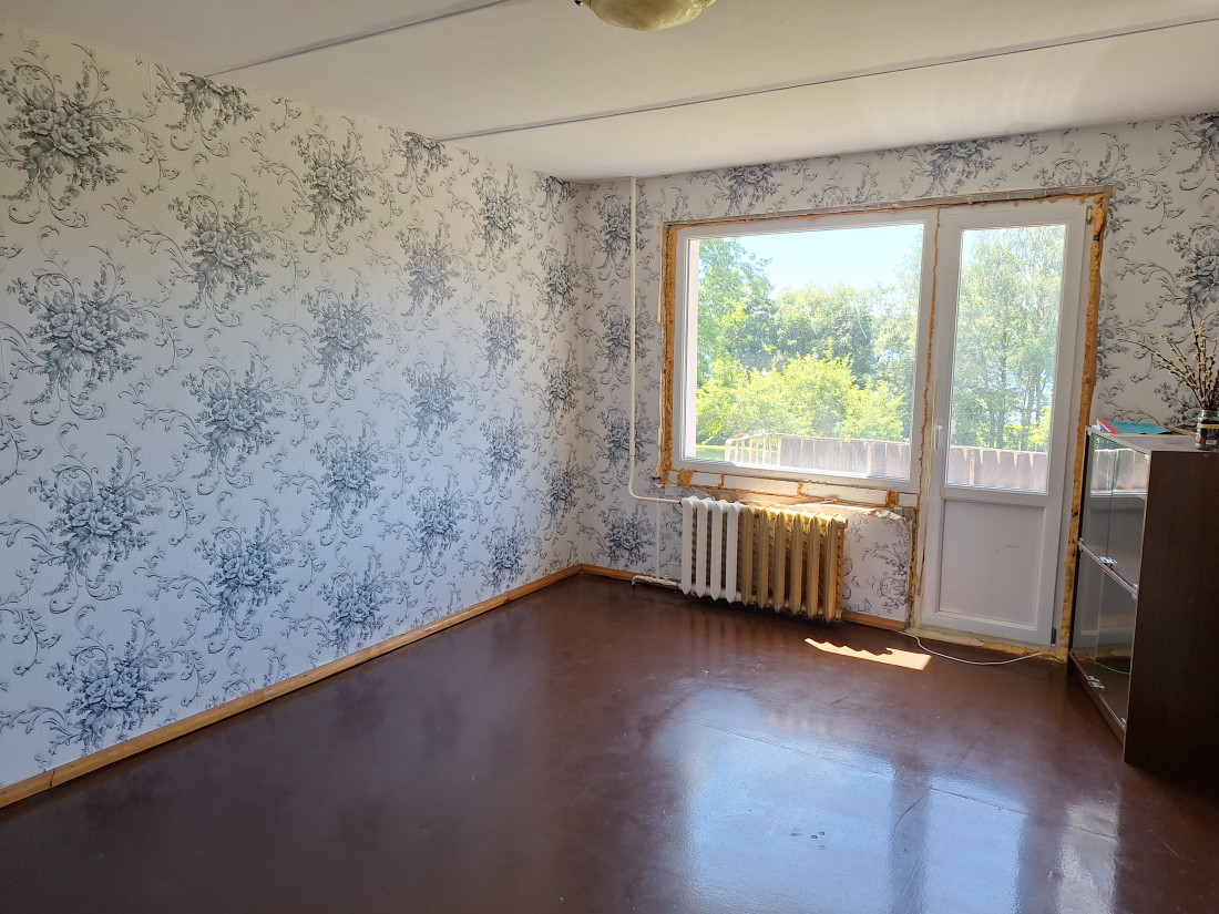 Room with light wallpaper and radiator