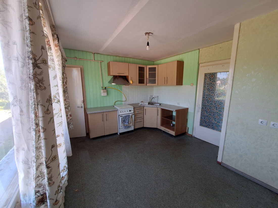  Kitchen with window, curtains, and stove.
