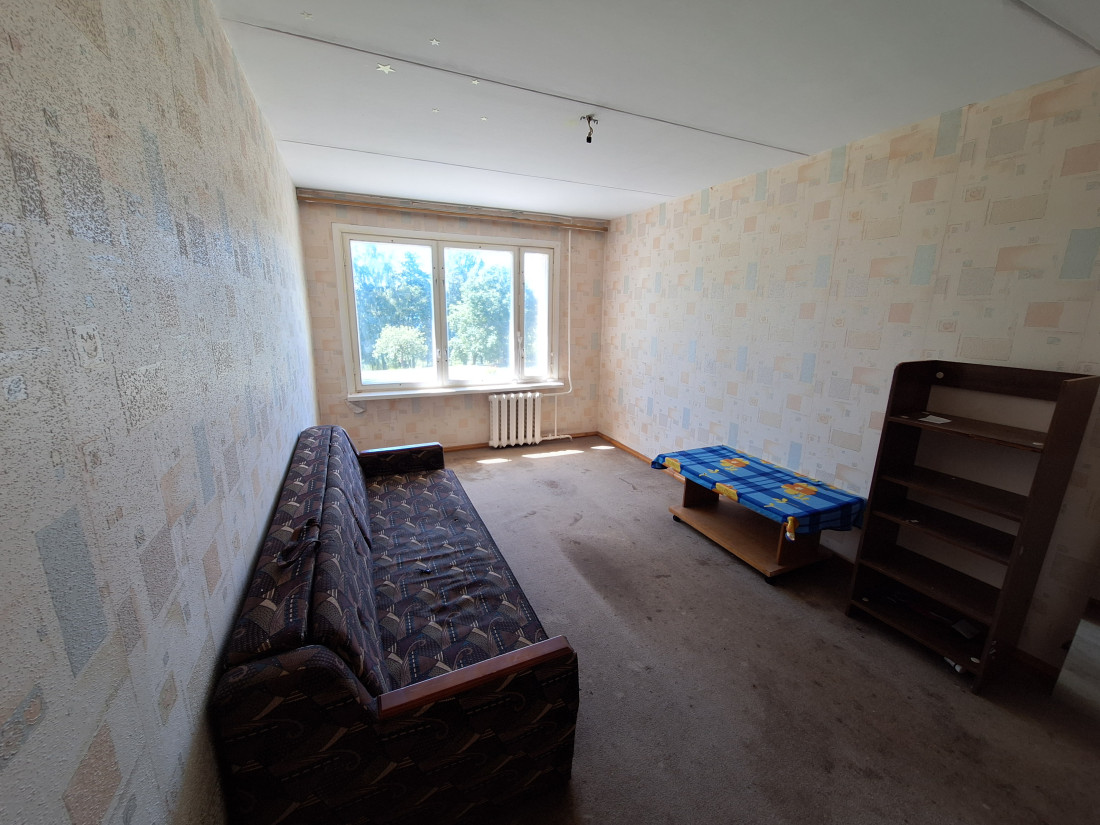 Spacious room with a large window and sofa.