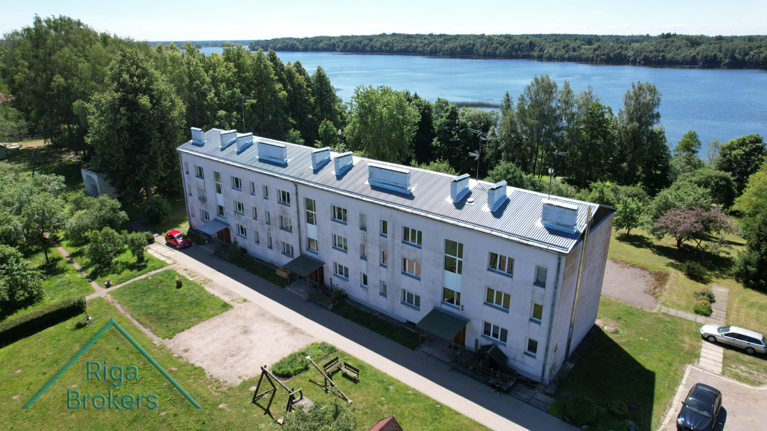  Residential building by the lake, green surroundings.