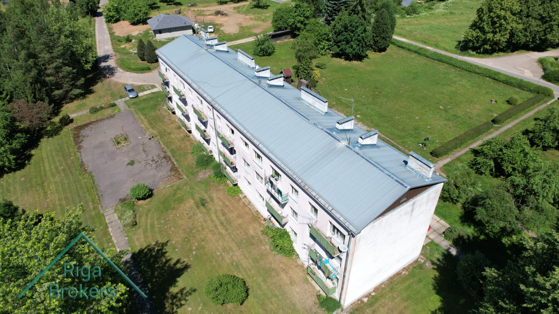 Residential building with balconies and lawn.