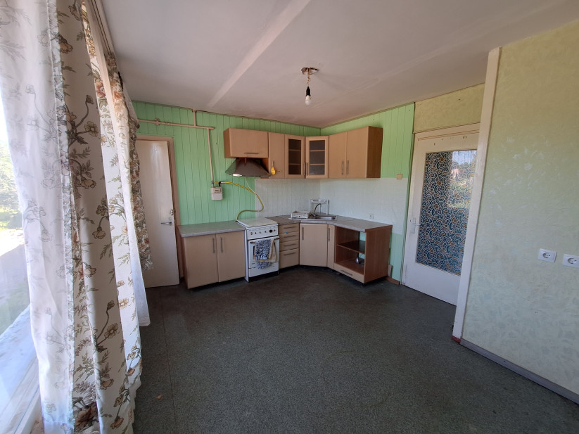  Kitchen with window, curtains, and stove.