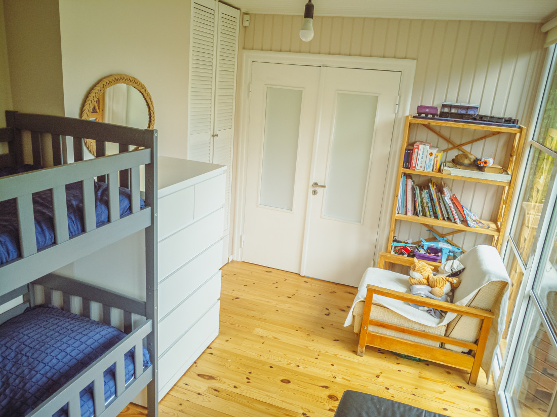 Children's room with bunk bed and shelves.