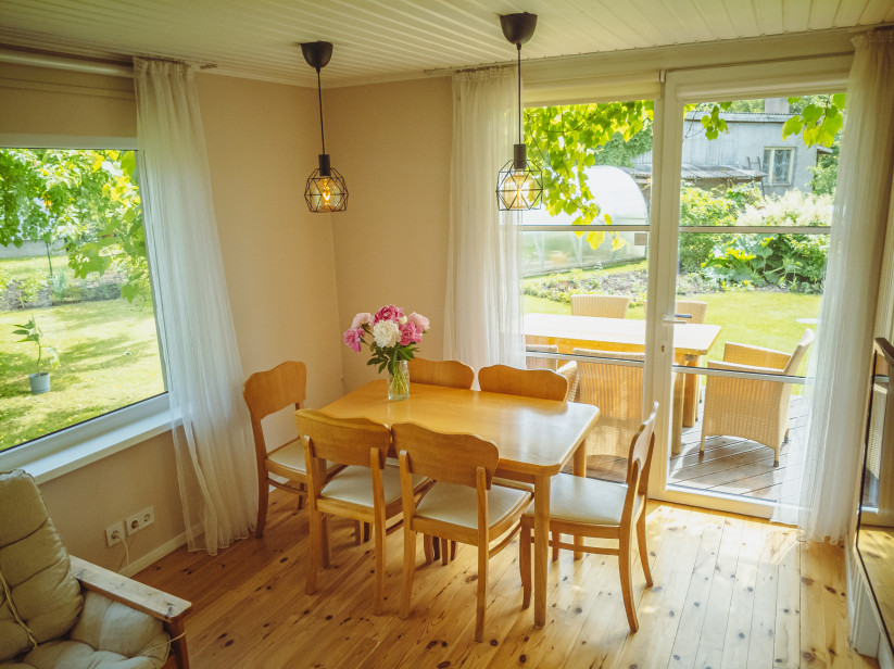 Dining area with wooden furniture and windows.