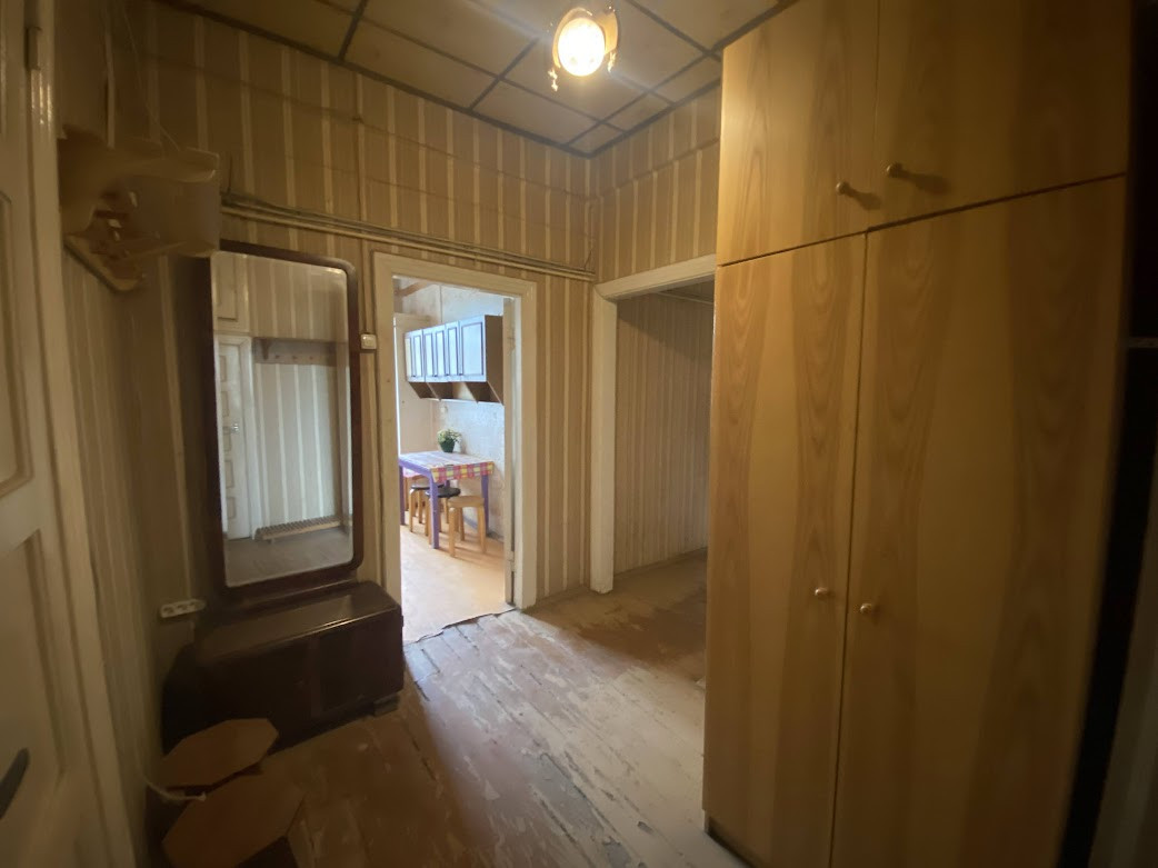 Hallway with wooden cabinets and a mirror.