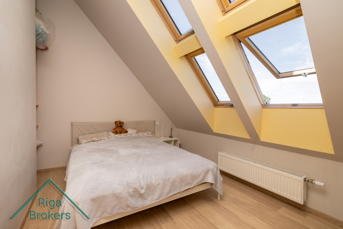 Small bright apartment bedroom with roof windows.