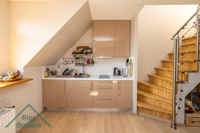 Small apartment kitchen with wooden stairs. 
