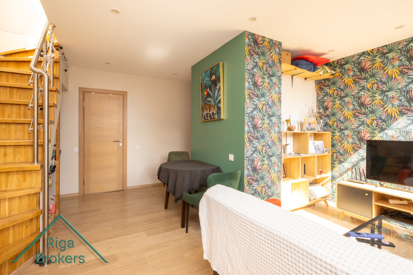 Apartment room with green wall finish and wooden furniture.