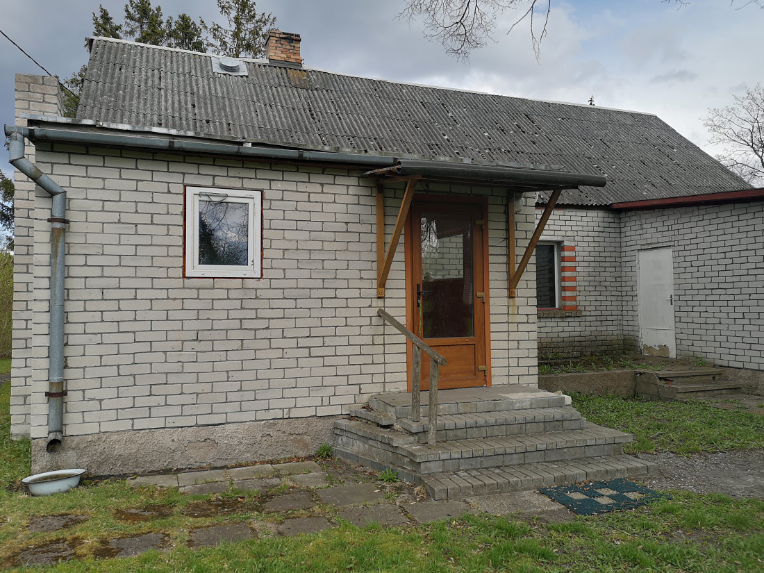 Mājas ieeja ar ķieģeļu kāpnēm.