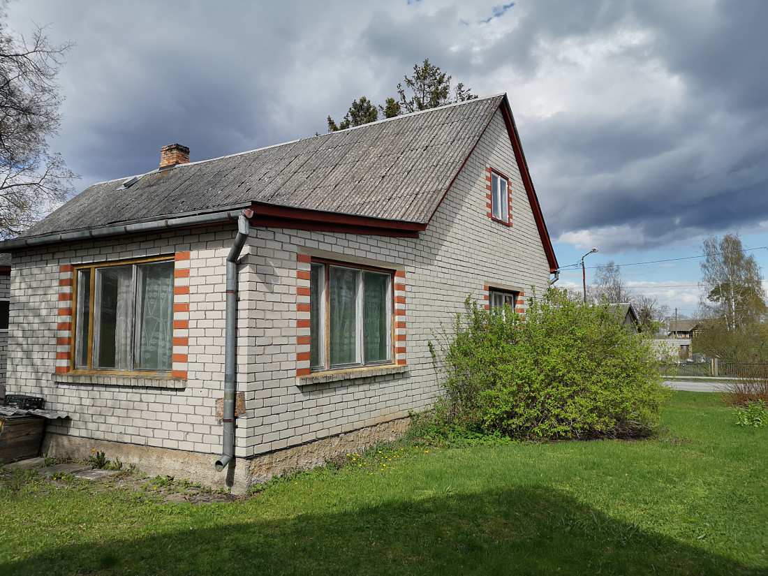 Ķieģeļu māja ar bēniņu logu.