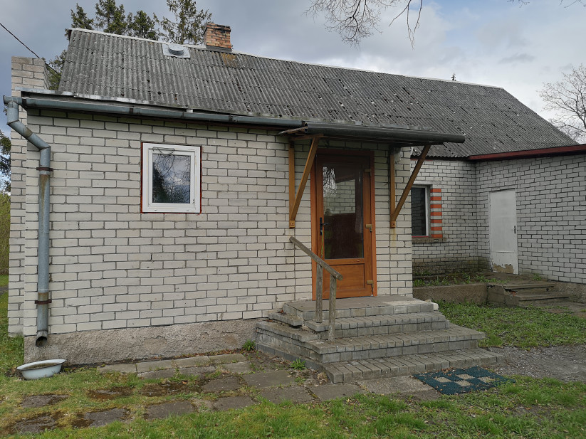 Mājas ieeja ar ķieģeļu kāpnēm.