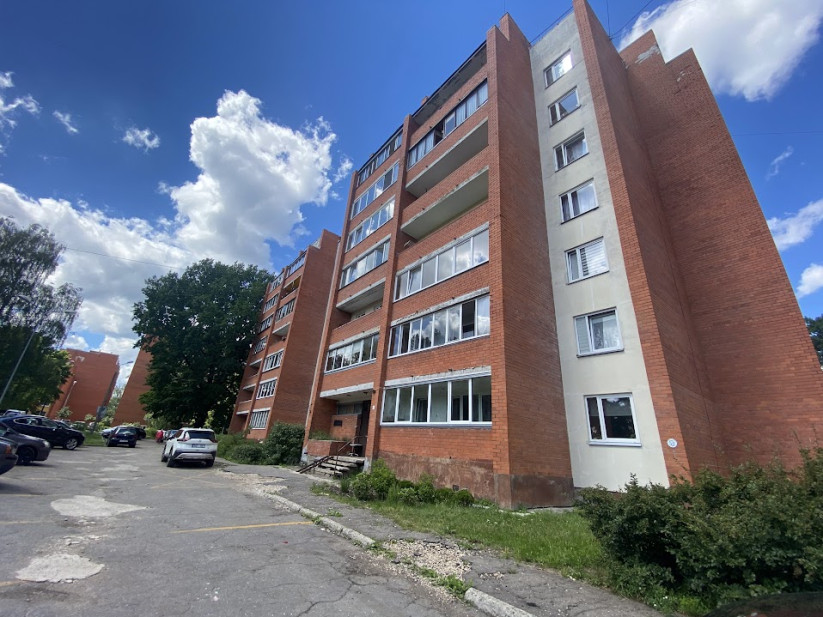Sarkanā ķieģeļa ēkas aizmugure ar logiem.